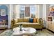 Cozy living room featuring a comfortable yellow sofa, stylish decor, and plenty of natural light at 4585 Summey St, North Charleston, SC 29405