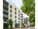 Well-maintained building with balconies, modern windows, and a welcoming entrance enhanced by mature trees at 5 Gadsdenboro St # 204, Charleston, SC 29401
