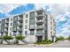 Elegant building exterior featuring multiple balconies, modern architecture and street view under a bright blue sky at 5 Gadsdenboro St # 204, Charleston, SC 29401