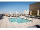 Rooftop pool with lounge chairs and umbrellas on a sunny day at 5 Gadsdenboro St # 204, Charleston, SC 29401