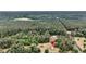 Aerial view of a home nestled in a wooded area with surrounding trees and greenery and open fields at 5056 Red Oak Rd, Cottageville, SC 29435