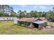 View of a barn on property surrounded by tall trees and with mobile home in the background at 5056 Red Oak Rd, Cottageville, SC 29435