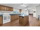 Bright kitchen with an island, wood-look flooring, tile countertops and white appliances at 5056 Red Oak Rd, Cottageville, SC 29435
