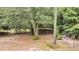 Rustic outbuildings surrounded by trees in the large, private backyard at 5056 Red Oak Rd, Cottageville, SC 29435