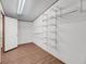 Bright walk-in closet features durable wood-look floors, shelving racks, and a door at 5056 Red Oak Rd, Cottageville, SC 29435