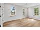 Light-filled bedroom featuring hardwood floors and three windows with picturesque views at 525 Old Bridge Ct, Mount Pleasant, SC 29464