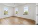 Bright bedroom boasts hardwood floors, white walls, trim, and three windows at 525 Old Bridge Ct, Mount Pleasant, SC 29464