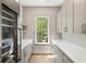 Charming pantry boasts custom cabinets, countertop space, a wine refrigerator, and a window overlooking the yard at 525 Old Bridge Ct, Mount Pleasant, SC 29464
