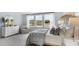 A bright bedroom featuring a decorative headboard, large windows, and neutral decor with a wicker accent chair at 527 Verdi Drive Dr, Summerville, SC 29486