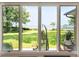 Scenic backyard view through large windows, featuring a lush green lawn and waterfront with hanging chair swings at 528 Wampler Dr, Charleston, SC 29412