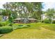Landscaped front yard with lush lawn and mature trees surrounding the brick home at 528 Wampler Dr, Charleston, SC 29412