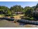 Waterfront home featuring lush landscaping, a sturdy seawall, and private access to the water at 528 Wampler Dr, Charleston, SC 29412