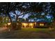 Well-maintained brick home featuring a spacious front lawn and mature trees at twilight at 528 Wampler Dr, Charleston, SC 29412