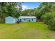 Wide view of a grassy backyard featuring a shed, patio with grill, and a lawn at 532 Sunset Dr, Charleston, SC 29407