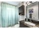 Bathroom with a dark vanity, shower with leaf-patterned curtain and medicine cabinet at 532 Sunset Dr, Charleston, SC 29407