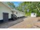 Rear view of home with light green siding, a dark trim and a utility shed with a dark door and gray stairs at 5774 Scott White Rd, Hollywood, SC 29449