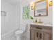 Bright bathroom featuring a shower and tub combination, a white toilet, and a wooden vanity with a white countertop at 5774 Scott White Rd, Hollywood, SC 29449