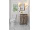 Bright bathroom features a wood vanity, stylish lighting, marble floors and a window at 5774 Scott White Rd, Hollywood, SC 29449