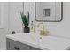 Elegant bathroom sink with gold fixtures, sleek countertop, and chic decor accents, illuminated by modern lighting at 5774 Scott White Rd, Hollywood, SC 29449