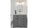Modern bathroom featuring gray vanity with a white countertop, gold fixtures, a black framed mirror, and stylish decor at 5774 Scott White Rd, Hollywood, SC 29449