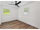 Bright bedroom features two windows and a modern ceiling fan above wood floors at 5774 Scott White Rd, Hollywood, SC 29449