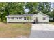 Charming single-story home with light green siding, dark trim, a gray roof, and a mix of gravel and concrete driveway at 5774 Scott White Rd, Hollywood, SC 29449