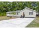 Charming single-story home with light green siding and dark trim plus a gray roof and a concrete driveway at 5774 Scott White Rd, Hollywood, SC 29449