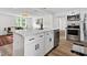 Open kitchen featuring white cabinets, stainless steel appliances, and a spacious quartz countertop island at 5774 Scott White Rd, Hollywood, SC 29449