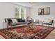 Bright living room featuring a patterned rug, comfortable seating, light walls, and natural light through large windows at 5774 Scott White Rd, Hollywood, SC 29449