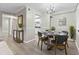 Bright dining room with a modern chandelier, table for four, light gray walls, and light wood-look flooring at 6240 Old Point Rd # C-8, Hanahan, SC 29410