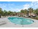 View of the community pool with chairs, palm trees, and a clear blue sky backdrop at 6240 Old Point Rd # C-8, Hanahan, SC 29410