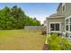 Spacious backyard features lush green grass, a wood fence, and a cozy patio area, perfect for outdoor relaxation at 725 Pepperbush St, Charleston, SC 29414