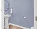 Half bathroom featuring a pedestal sink, round mirror, and blue walls at 725 Pepperbush St, Charleston, SC 29414