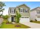 Charming two-story home with manicured lawn, a two-car garage, and classic curb appeal at 725 Pepperbush St, Charleston, SC 29414