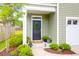 Inviting entryway with a black door adorned with a green wreath and beautiful landscaping at 725 Pepperbush St, Charleston, SC 29414
