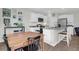 White kitchen with granite counters, stainless appliances, island with seating adjacent to the dining area at 725 Pepperbush St, Charleston, SC 29414