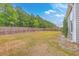 Large backyard featuring a lawn, wooden fence, and a fire pit area, perfect for outdoor entertaining at 7690 High Maple Cir, North Charleston, SC 29418