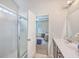 Partial bathroom view through glass door, including vanity and glimpse of a bedroom with a blue accent wall at 7690 High Maple Cir, North Charleston, SC 29418