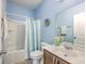 Bright blue bathroom featuring a vanity with sink and a shower-tub combo with a blue and white striped curtain at 7690 High Maple Cir, North Charleston, SC 29418
