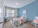 Charming bedroom with a blue accent wall, a comfortable bed with decorative pillows, and a cozy writing desk at 7690 High Maple Cir, North Charleston, SC 29418
