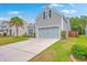 Charming home featuring a two-car garage, well-manicured lawn and a concrete driveway at 7690 High Maple Cir, North Charleston, SC 29418