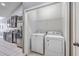 Functional laundry area with a washer, dryer, and shelving, located near the kitchen at 7690 High Maple Cir, North Charleston, SC 29418
