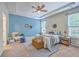 Comfortable main bedroom featuring a bed with blue accents, tray ceilings, and natural light at 7690 High Maple Cir, North Charleston, SC 29418