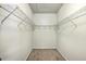 Empty walk-in closet with wire shelving on both sides, carpeted floor, and a ceiling access panel at 7690 High Maple Cir, North Charleston, SC 29418