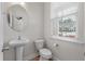 Cozy half bathroom featuring a pedestal sink, toilet, and window at 7780 Montview Rd, North Charleston, SC 29418
