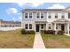 Charming two-story townhome with manicured lawn and inviting walkway to a dark blue front door at 7780 Montview Rd, North Charleston, SC 29418