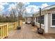 Wooden back deck with wooden railings leads to house with multiple windows and sitting area with outdoor furniture at 8476 Old Georgetown Rd, McClellanville, SC 29458