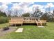 Back of house with wooden deck and steps leading to spacious grass backyard at 8476 Old Georgetown Rd, McClellanville, SC 29458
