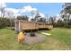 View of back of house with wooden deck and fire pit in spacious green backyard at 8476 Old Georgetown Rd, McClellanville, SC 29458