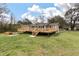 View of back of house and deck with steps leading to spacious grass backyard at 8476 Old Georgetown Rd, McClellanville, SC 29458